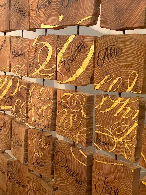 Detail goldene und gebrannte Schreibschrift auf Holz-Täfelchen