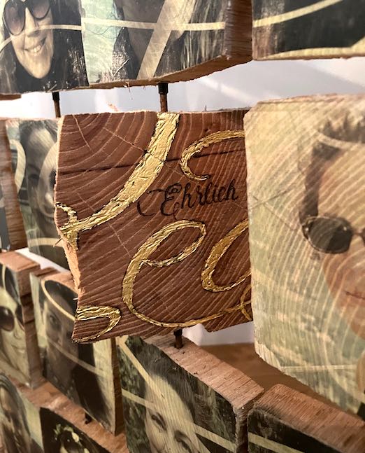 Detail von gedrehten Holztäfelchen mit Portraits und Schreibschrift