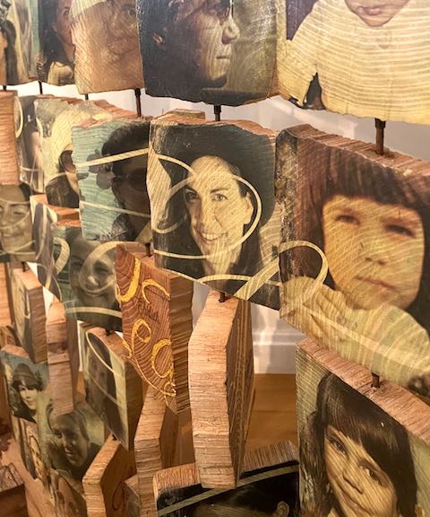 Seitenansicht gedrehter Holztäfelchen mit Portraits und Schreibschrift