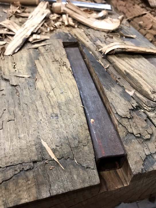 Metallrohr in Altholz eingelassen