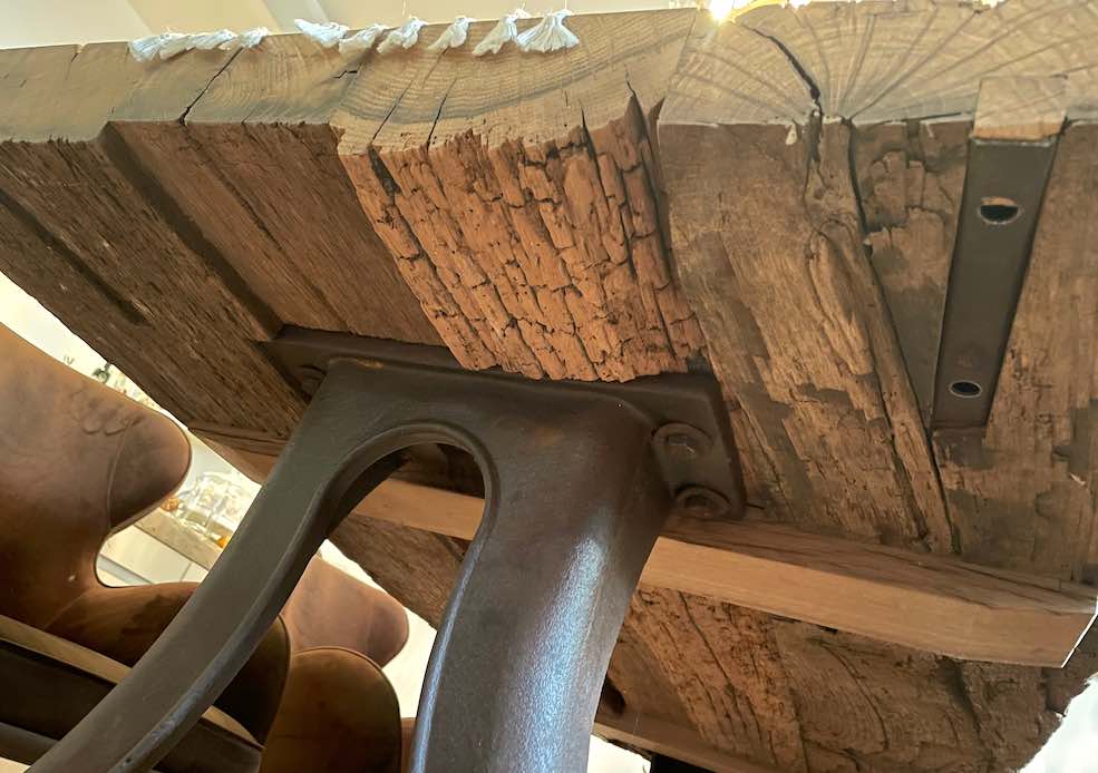 Untersicht rustikale Tischplatte aus altem Eichenholz mit Gußeisen-Fuß