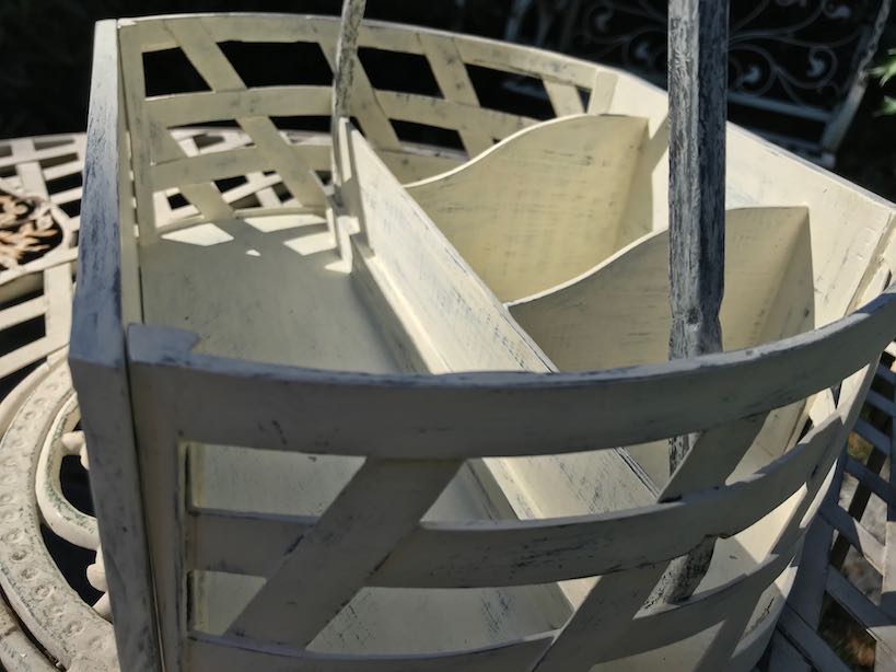 Seitenansicht Holzkorb mit Geflecht und Metallbügel auf Gartentisch