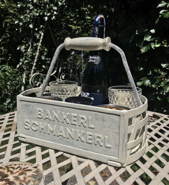 Weißer Holzkorb auf Gartentisch mit Snacks/Aperitif