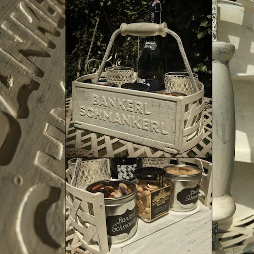 Weißer Holzkorb auf Gartentisch mit Snacks/Aperitif