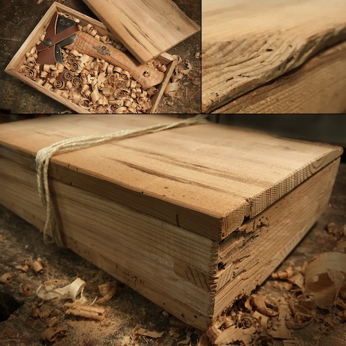 Geschenkbox aus altem Fichtenholz mit Handbeil auf alter Werkbank