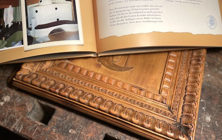 Holz-Schuber und Buch auf Werkbank