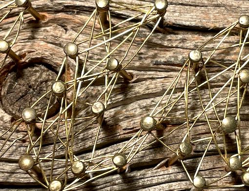 Close-up Faden-Bild aus Messingnägeln und -draht auf verwittertem Holz