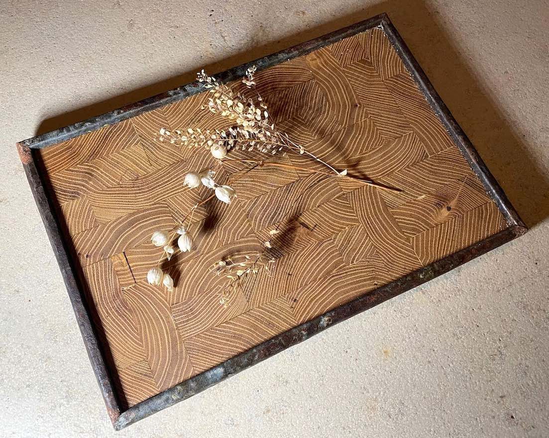 Tablett aus Robinien-Stirnholz und Rahmen aus rostigem Blech mit Deko auf Steinplatte