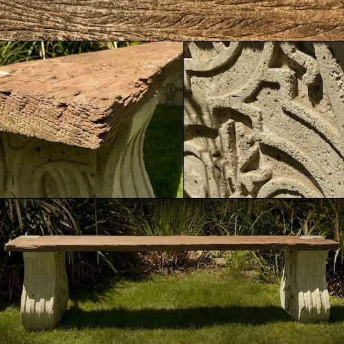 Sitzbank aus altem, verwittertem Holz auf ornamentalen Betonsockeln im Garten