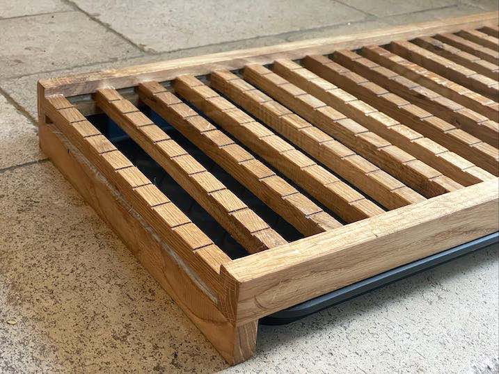 Ablage für Snowboard und -Schuhe aus altem recyceltem Eichenholz auf Steinboden