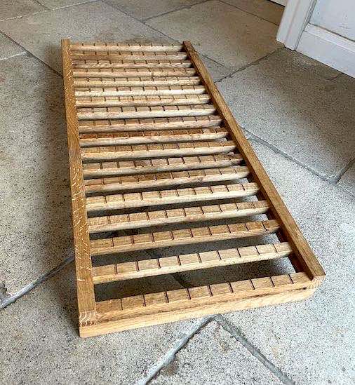 Ablage für Snowboard und -Schuhe aus altem recyceltem Eichenholz auf Steinboden