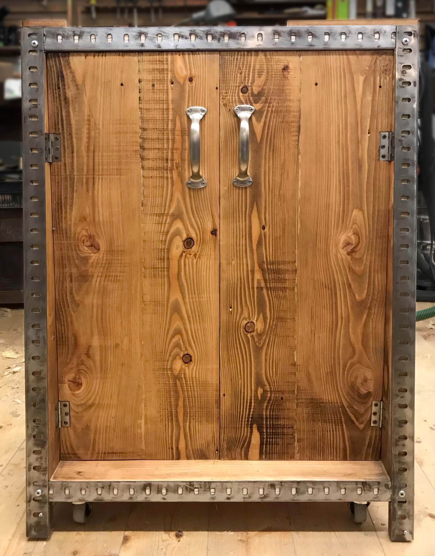 Front von Maschinenschrank aus altem Holz und Stahlprofilen in Werkstatt