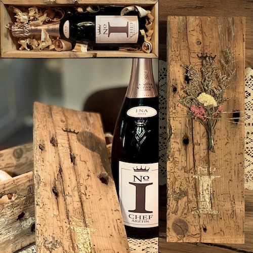 Geschenkbox aus altem Holz mit Deckel und Sektflaschen "No1 Chef-Ärztin" auf Tisch