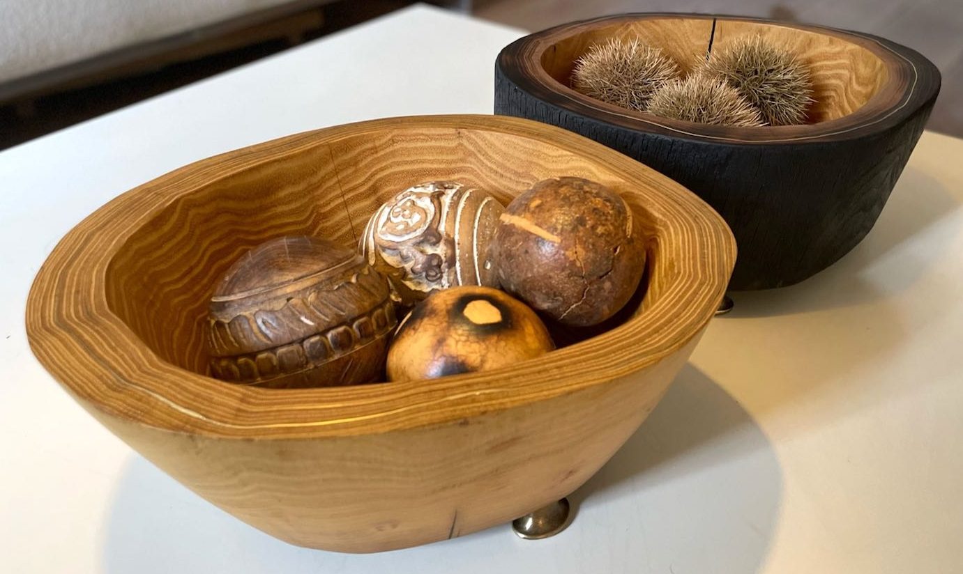 2 Schalen aus Robinienholz (natur und gebrannt) mit Deko auf Couchtisch