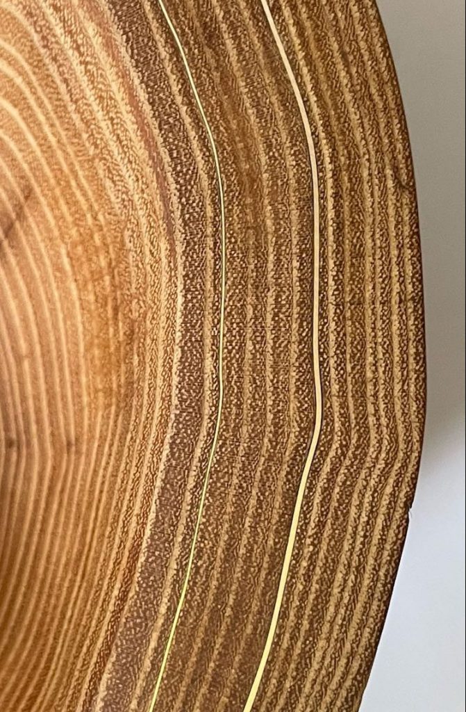 Detail vom Rand einer Schale aus Robinienholz mit Messing-Inlay