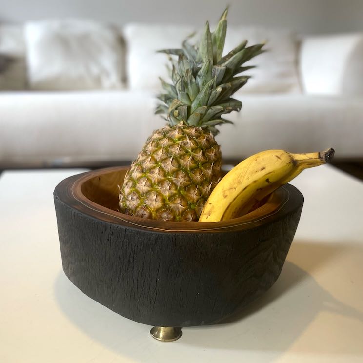 Holzschale aus geschwärztem Robinienholz auf Couchtisch mit Obst