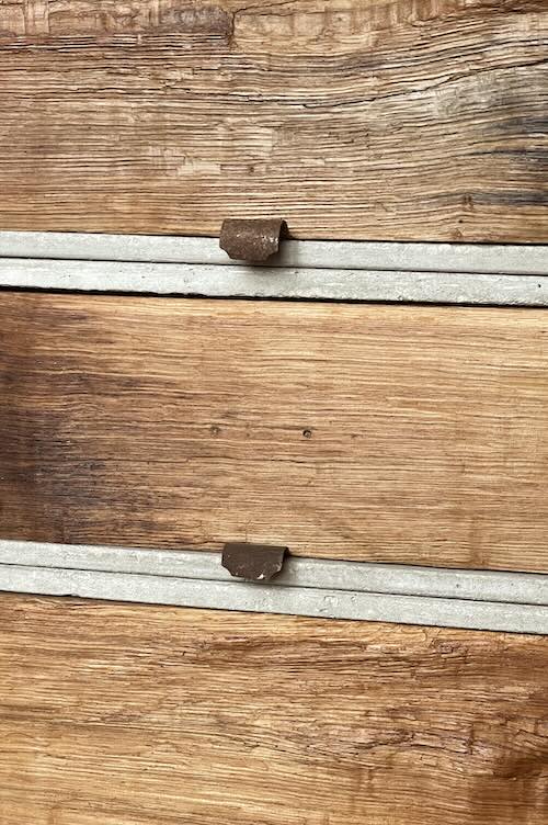 Detail von Altholz-Schubladen in Beton-Rahmen