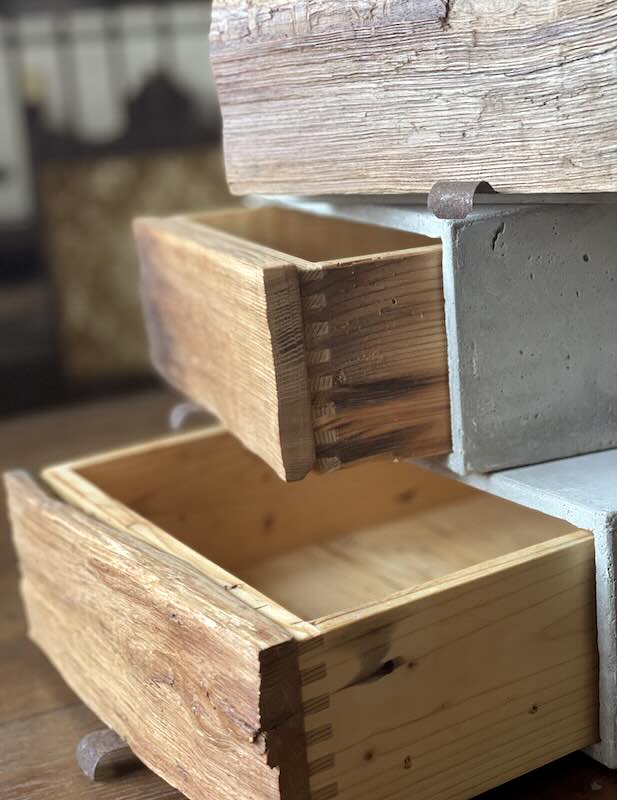 Detail von Altholzschubladen in gestapelten Beton-Boxen auf Schreibtisch