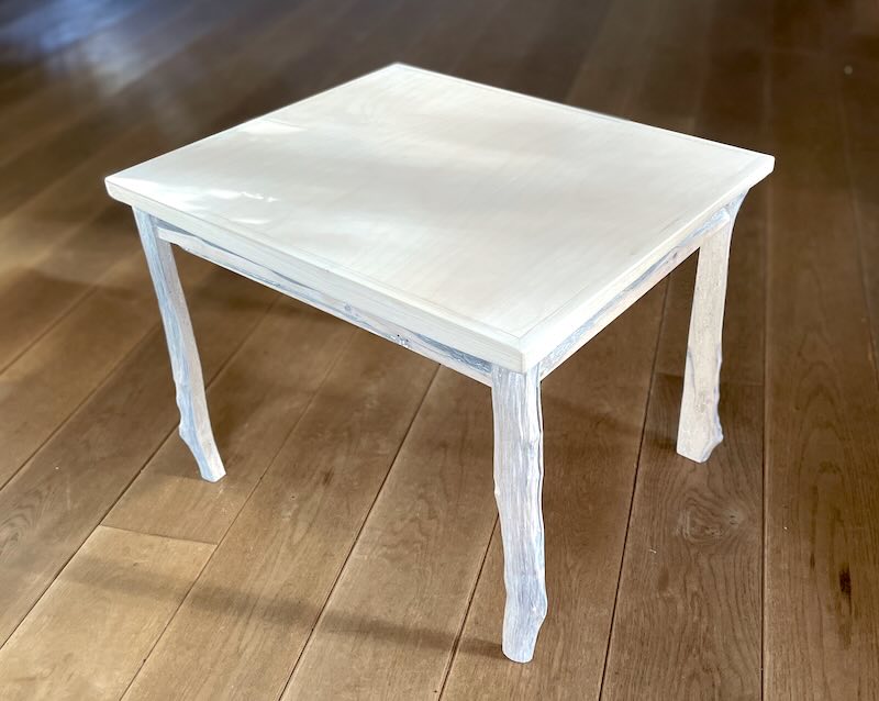 Kindertisch aus hellem Natur-Holz auf Eichendielenboden