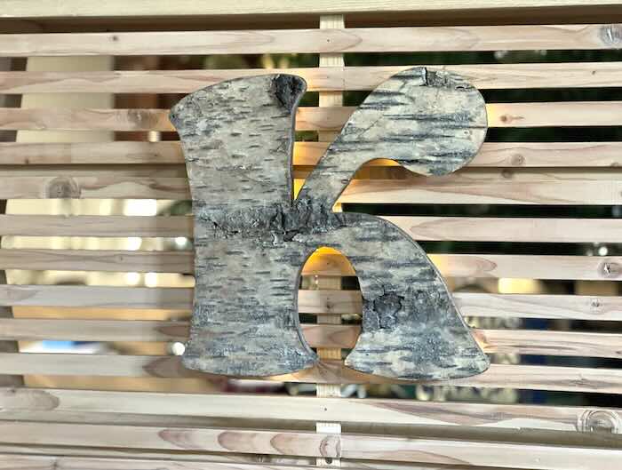 K-Initial aus Birkenrinde an Verkaufstheke für Kinder aus Holz